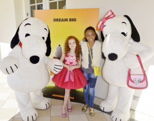 Francesca Capaldi and Skai Jackson posed with Snoopy and Belle in front of poster for the new Peanuts Movie 
